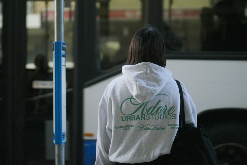 A woman at a bus stop.