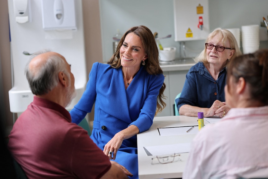 Princess Kate sitting down at a table talking with cancer patients