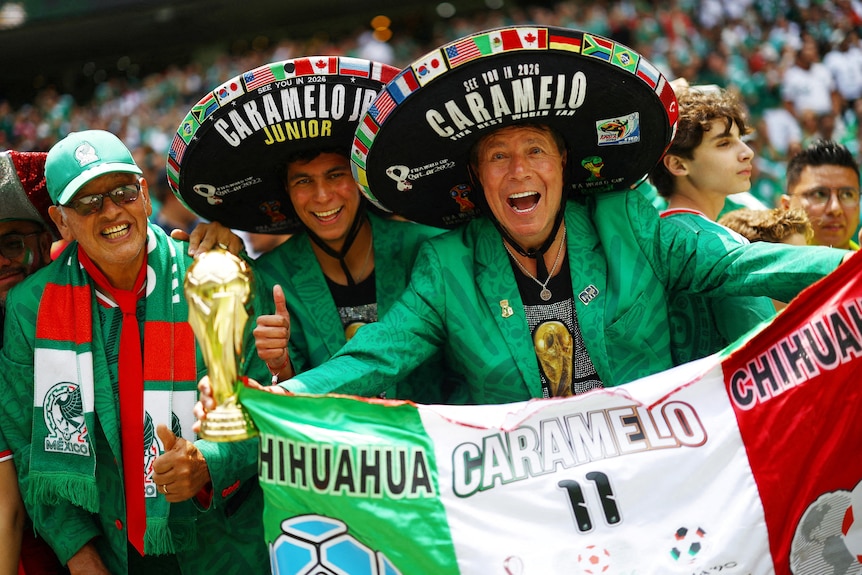 three men wearing sombreros and mexican cultural dress holding a flag