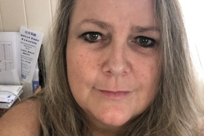 A middle aged woman smiling at the camera