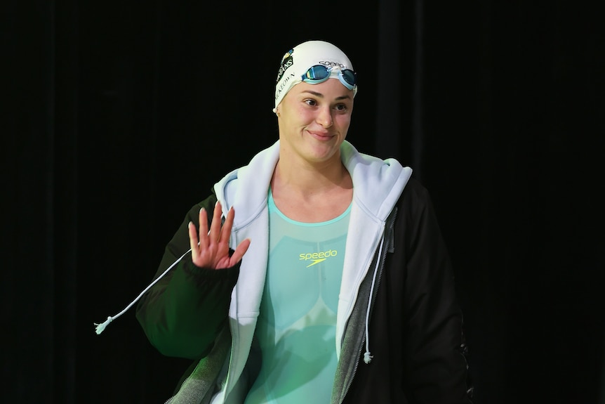 Swimmer Kaylee McKeown waves as she walks to the blocks.