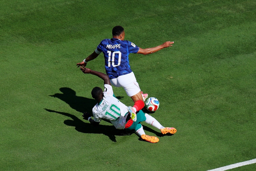 Sadio Mané hits the ground under Kylian Mbappé.