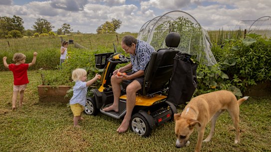 Peter Riley at home in Razorback with his grandchildren, Samson, 1, Noah, 3, and Abigail, 5, and family dog Atticus earlier this year, before his move into palliative care.