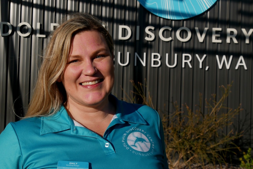 A woman in blue shirt in front of Dolphin Discovery Centre