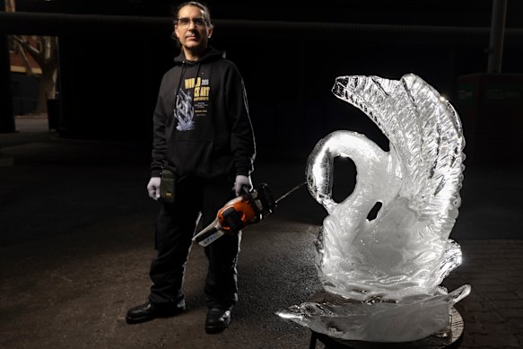 Cool career: Ice sculptor Kevin Kapusi Starow with a swan he crafted from a block of ice.