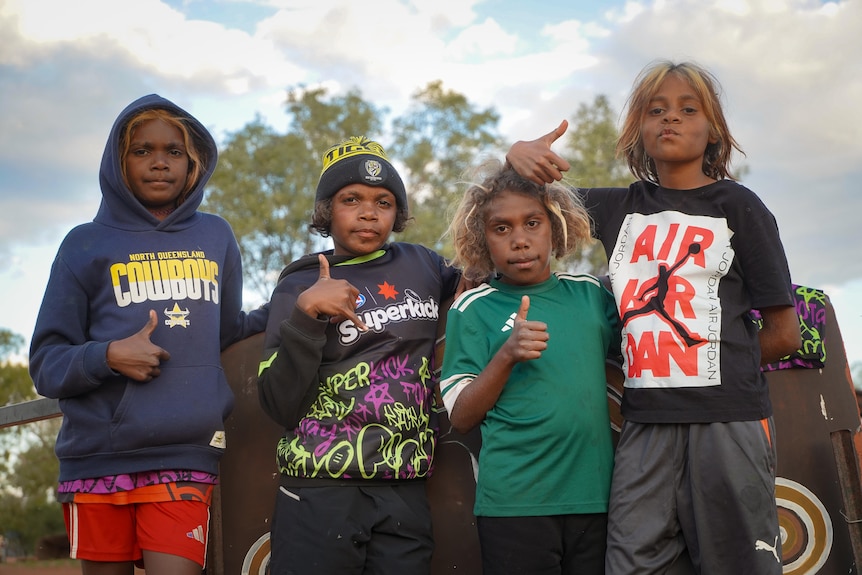 Four young children mug for the camera.