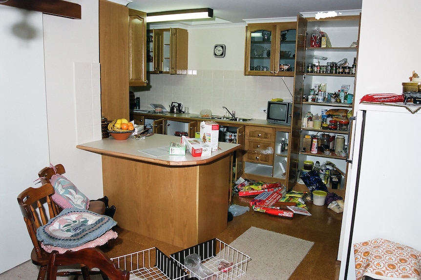 An old photo scan showing a kitchen that's been rummaged through by robbers. 