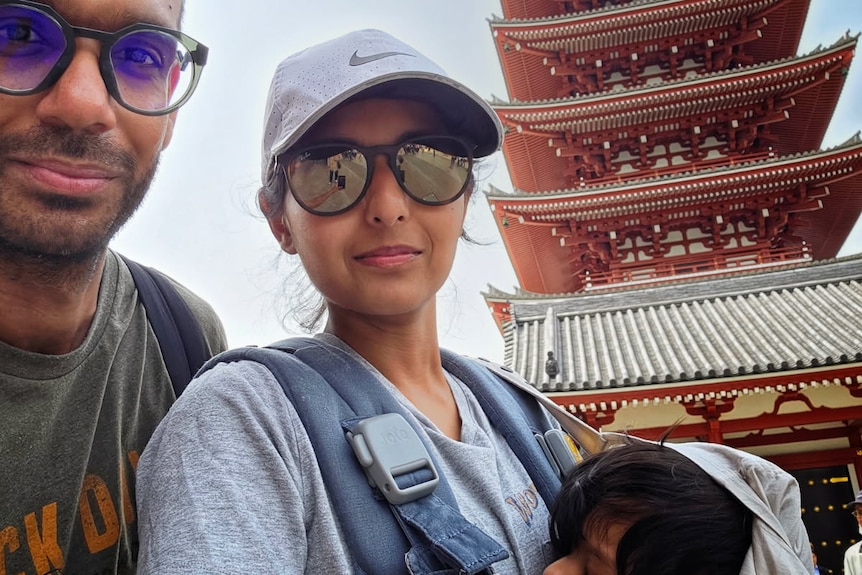 A young family in front of an asian temple.