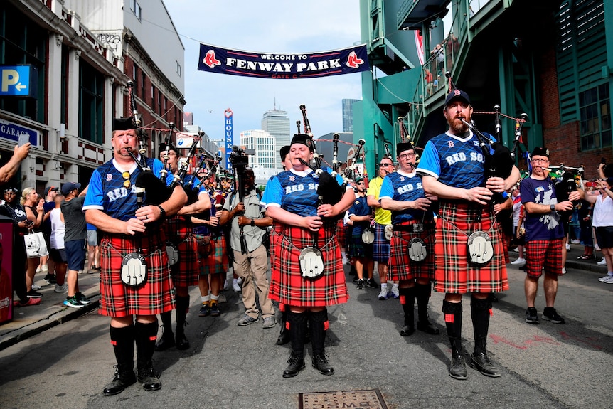 a scottish bagpipe band plays on a boston street