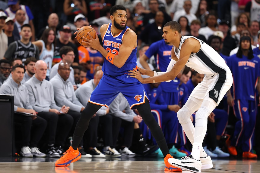 Karl-Anthony Towns prepares to make a move against Victor Wembanyama in the NBA Finals.