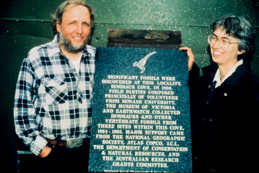 Two paleaontologists with a plaque honouring their work.