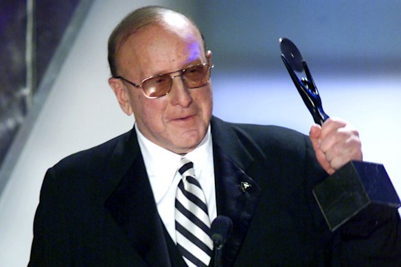 Clive Davis holds up his statue as he is inducted into the Rock and Roll Hall of Fame in 2000.