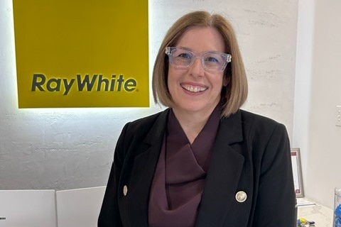 A woman smiles at the camera.
