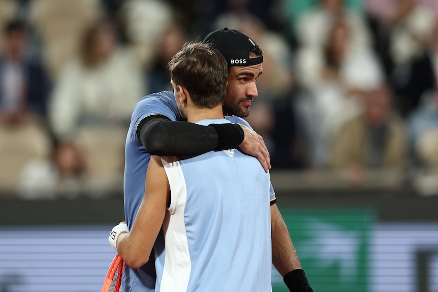 Matteo Berrettini hugs Matteo Arnaldi at the net after their French Open quarterfinal.