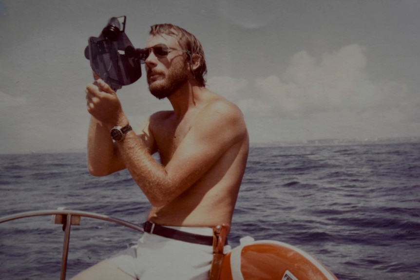 a young man taking a photograph on a boat.