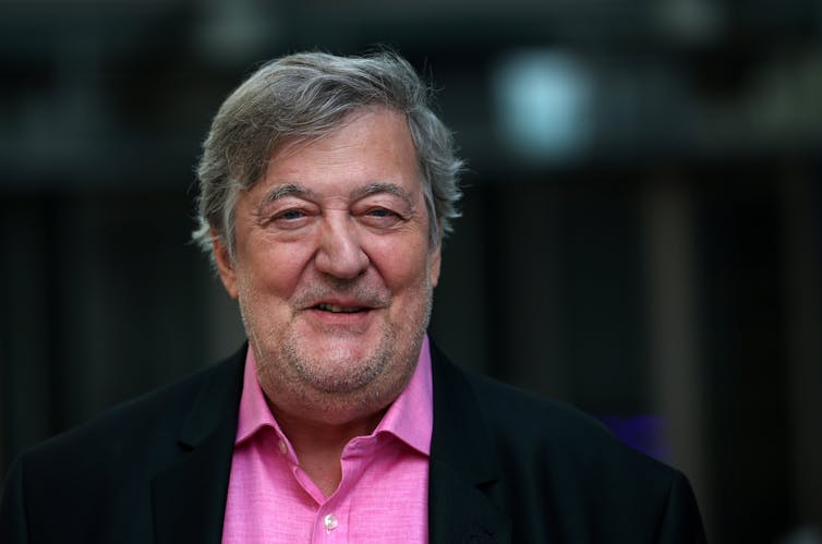 a man in a pink shirt and black suit jacket