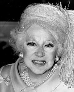 an old woman with pearls and too much mascara