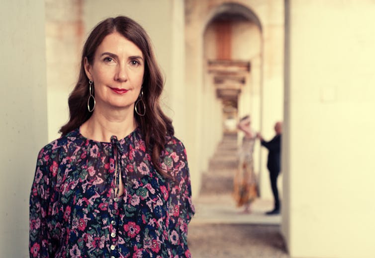 a smiling woman in a floral dress at a university