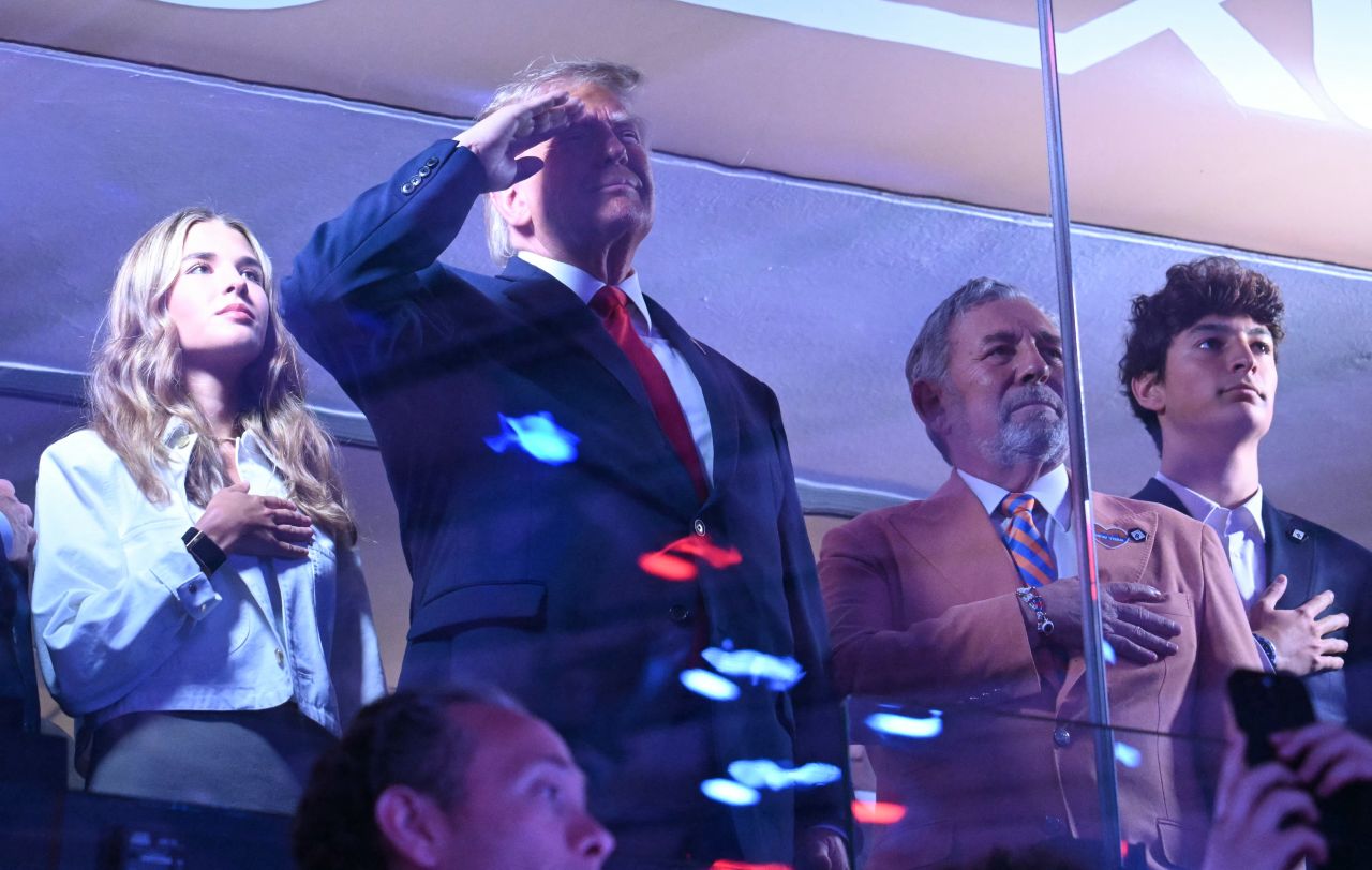 President Donald Trump salutes during the national anthem before the game.