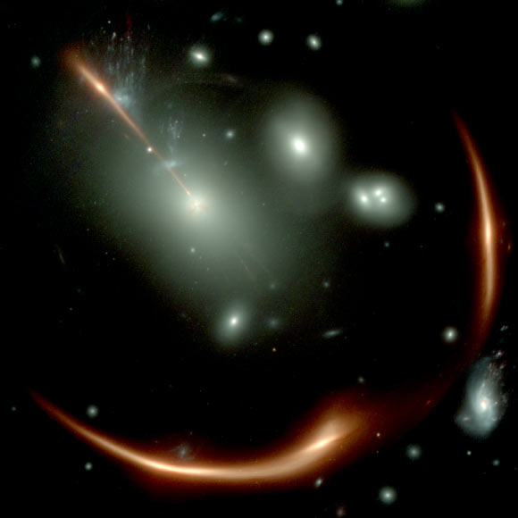 This Webb image shows the highly distorted red galaxy MRG-M0138 seen through a foreground cluster of galaxies (white sources). Image credit: NASA / ESA / CSA / Webb.
