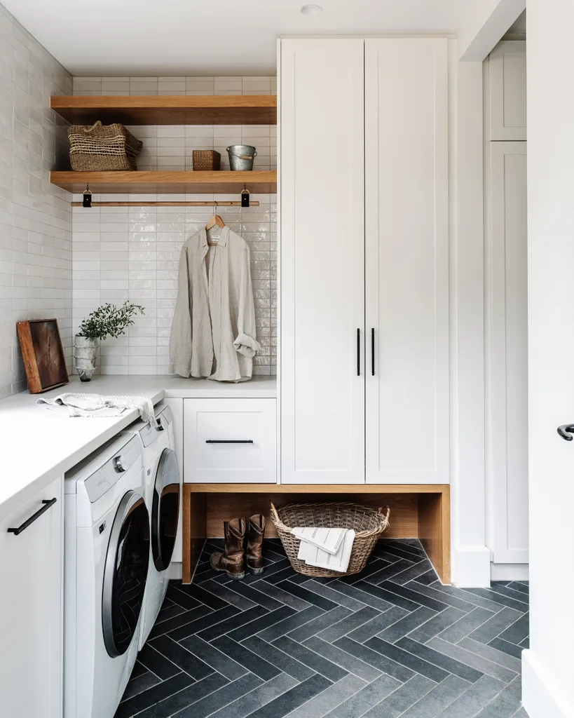 White country style laundry and mudroom with grey herringbone tile flooring.