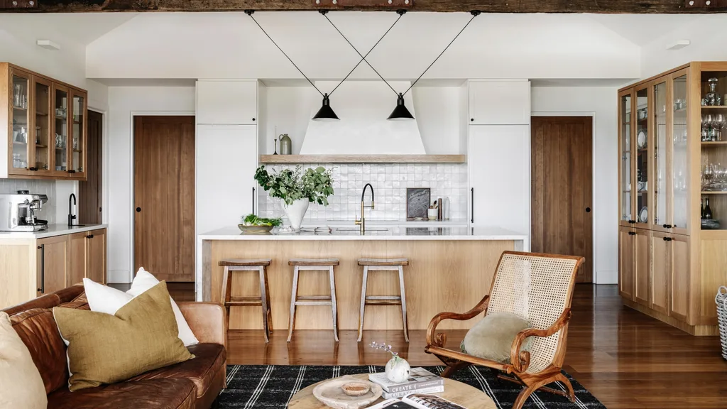 A timber country open plan kitchen with clay splashback tiles, a stone benchtop and hardy timber surfaces.