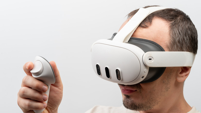 A man wearing a VR headset and using a controller.