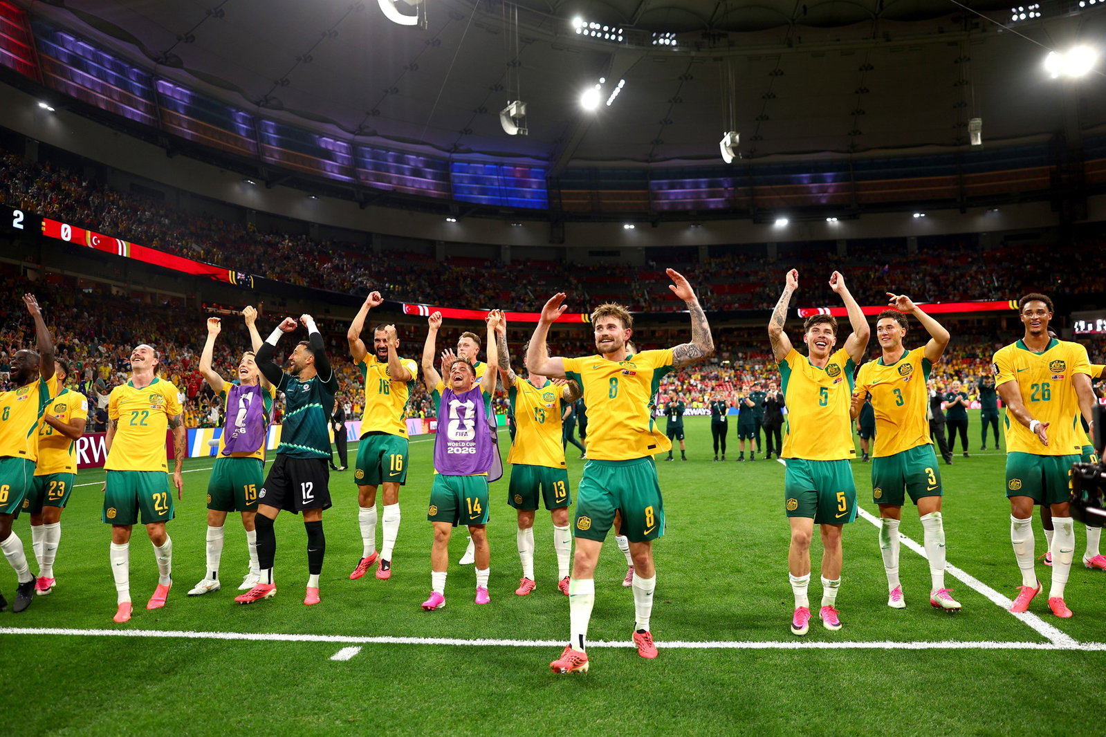 Socceroos players celebrate with the travelling fans after the 2-0 win.