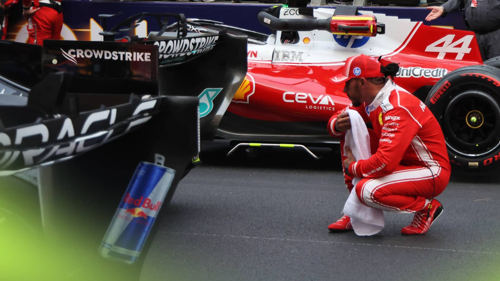 Lewis Hamilton crouching behind the rear wing of Kimi Antonelli's Mercedes on the grid in Monaco
