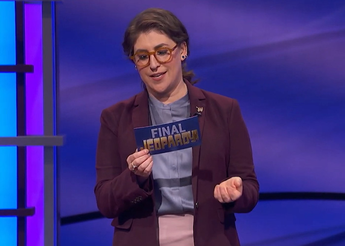 Mayim Bialik holding Final Jeopardy card on game show set Mayim Bialik holding Final Jeopardy card on game show set