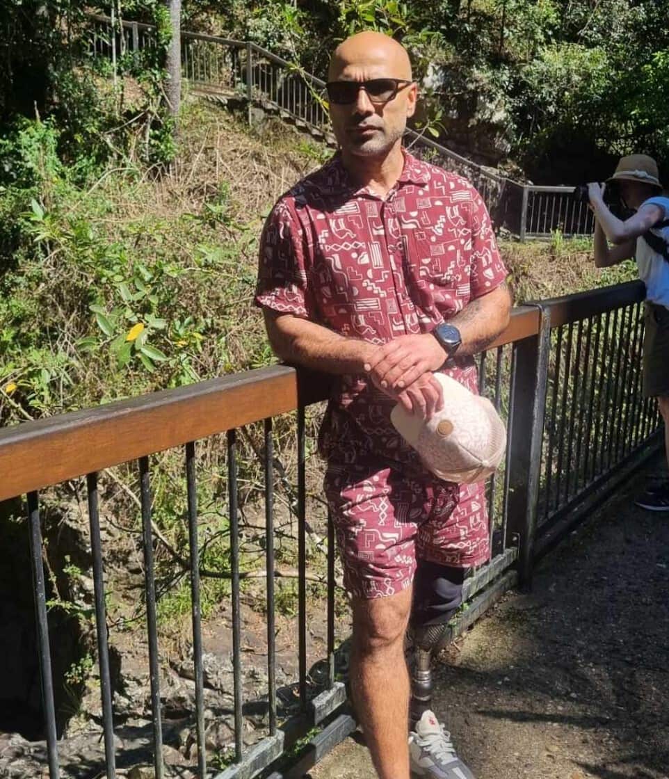 A man posing outside in bushland for a photo.