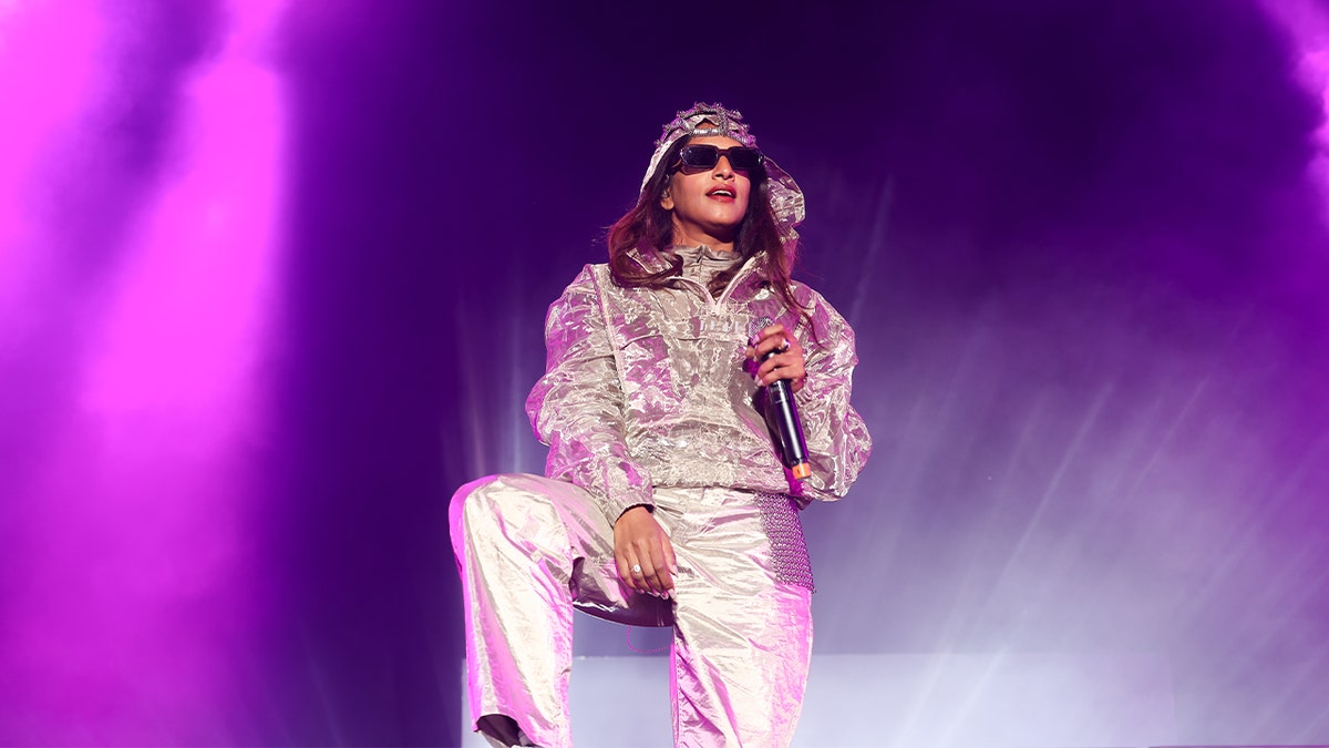 M.I.A. performs on stage in a silver suit