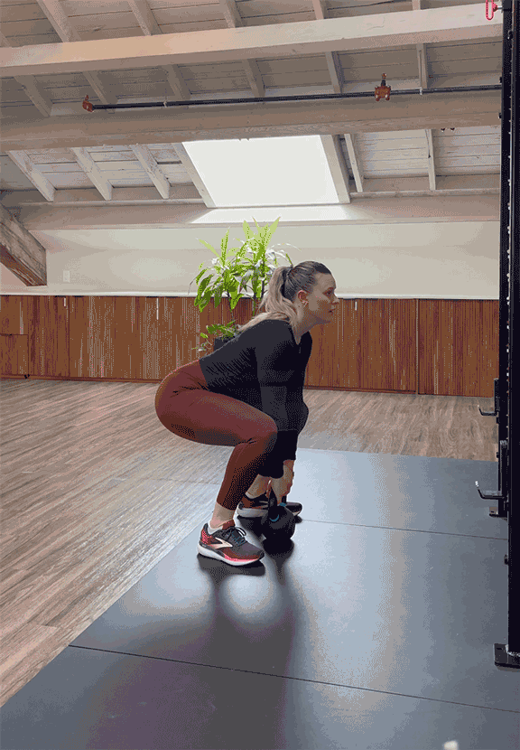 woman doing power clean with kettlebell woman doing power clean with kettlebell