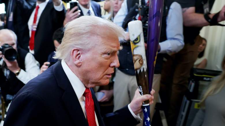 U.S. President Donald Trump carries baseball bats.