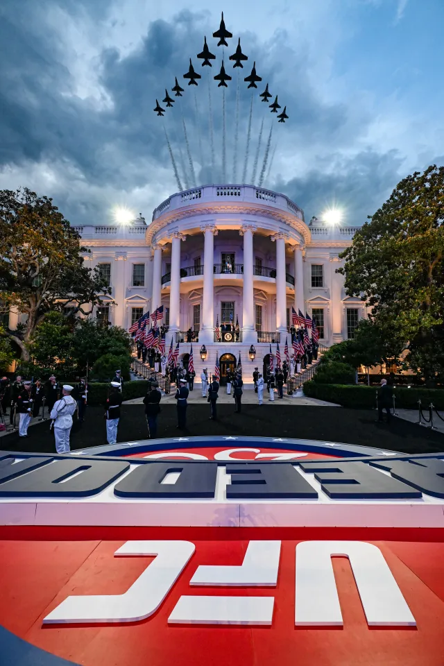 President Donald Trump and President and CEO of the UFC Dana White arrive for an Ultimate Fighting Championship match at the White House as a 12-ship formation consisting of six U.S. Air Force Thunderbirds F-16 Fighting Falcons and 6 U.S. Navy Blue Angels fly over the White House on June 14, 2026 in Washington, DC