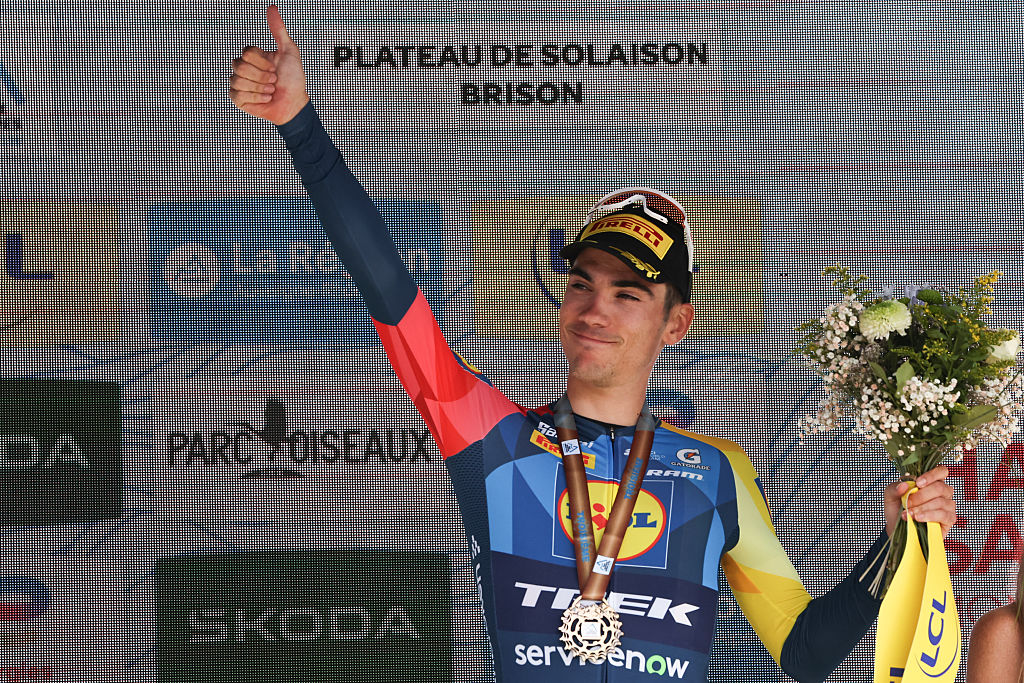 Third-placed Lidl-Trek's Spanish rider Juan Ayuso celebrates on the podium after the 8th and final stage of the Tour Auvergne-Rhone-Alpes cycling race (formerly known as the Criterium du Dauphine), 120,1km between Beaufort and Plateau de Solaison, in the French Alps on June 14, 2026. (Photo by Anne-Christine POUJOULAT / AFP)