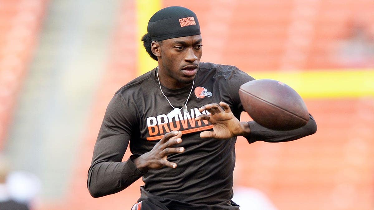 Cleveland Browns quarterback Robert Griffin III warming up on the field.
