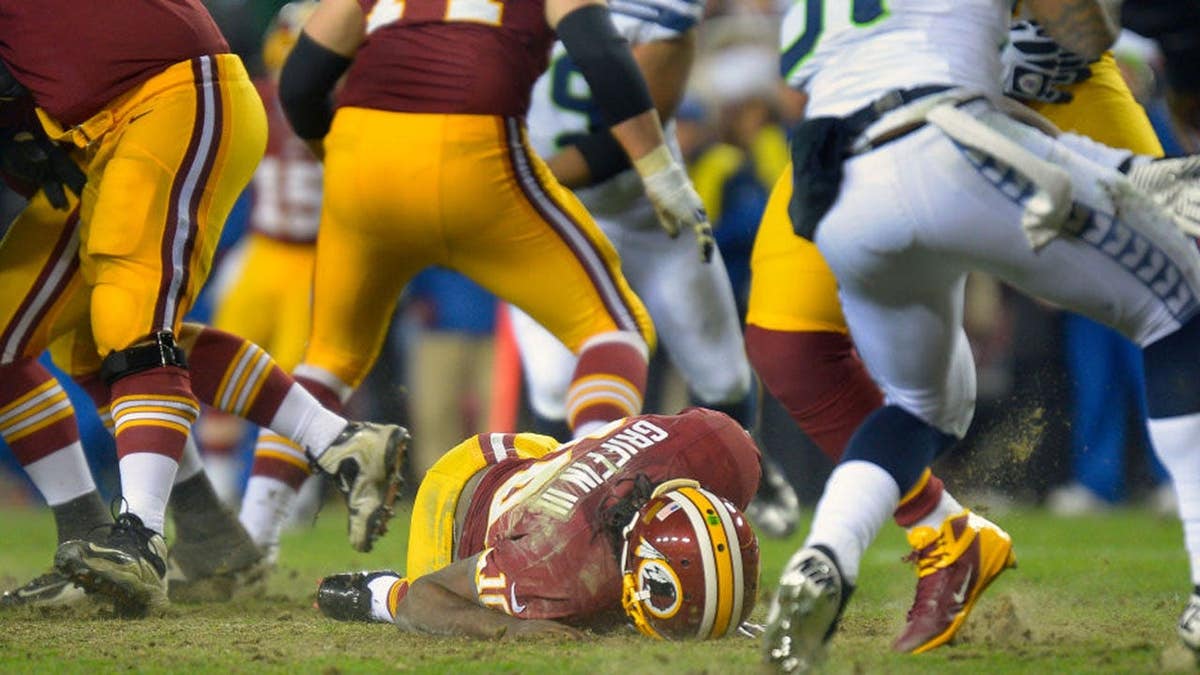 Washington quarterback Robert Griffin III lying on the ground after injuring his right knee during a game.