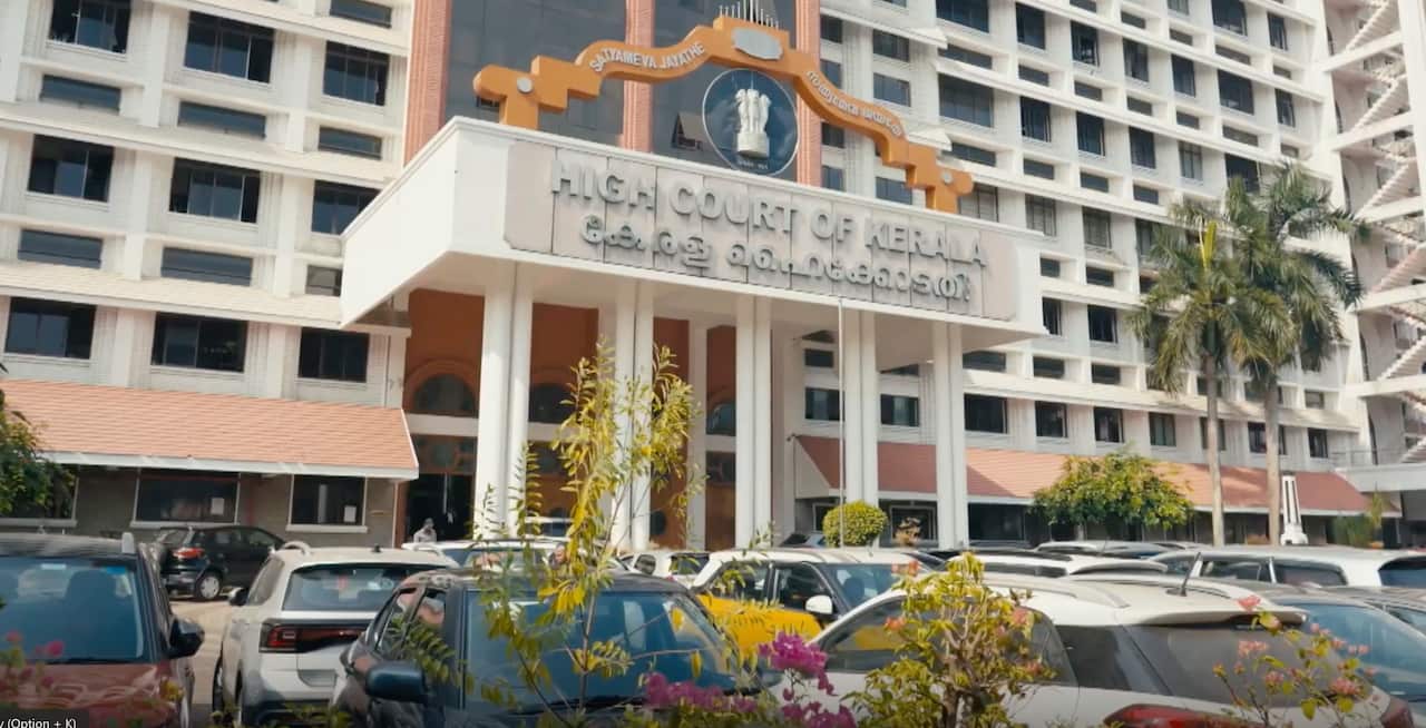 A large, official building with the words 'High Court of Kerala' on the front. 