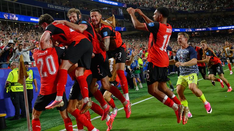 Austria's players celebrate wildly after Sasa Kalajdzic's last-gasp equaliser