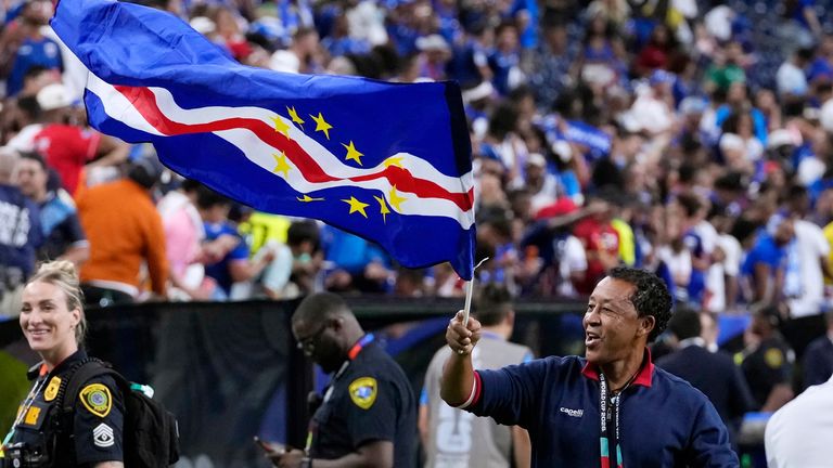 Cape Verde head coach Bubista waves the flag as he celebrates reaching the round of 32
