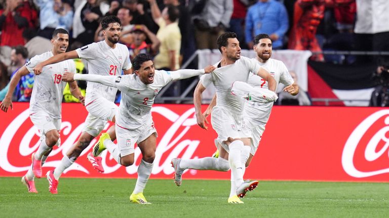 Iran's Shoja Khalilzadeh (4) celebrates with teammates after scoring a goal, which was overturned as an offside