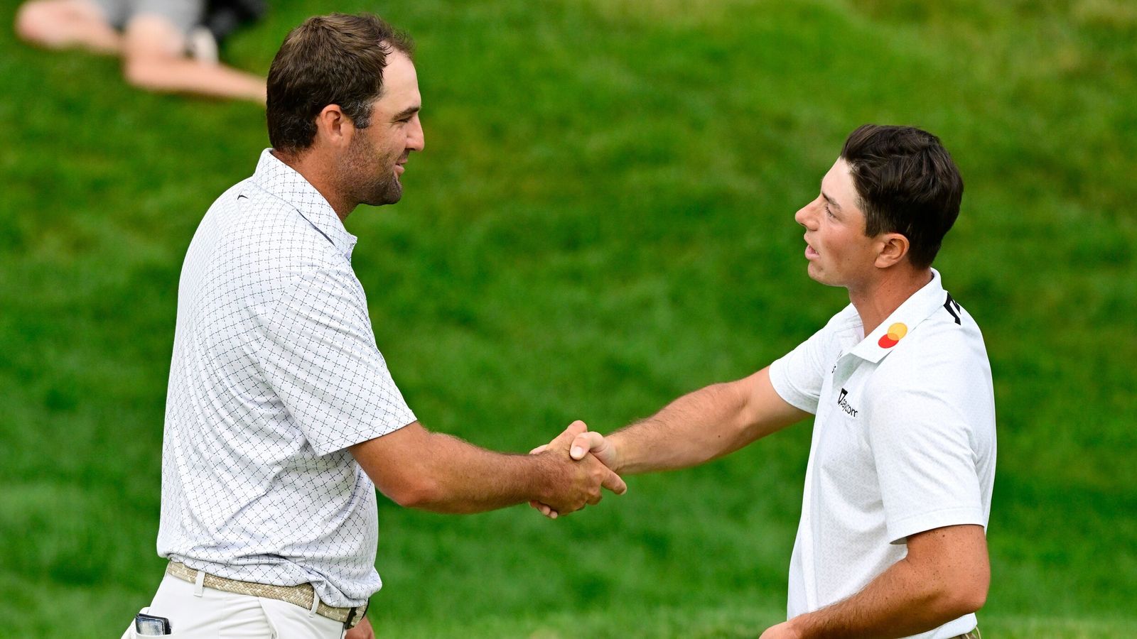 Scottie Scheffler shakes hands with Viktor Hovland on the 18th green after finishing the third round. (AP Photo/Jessica Hill)