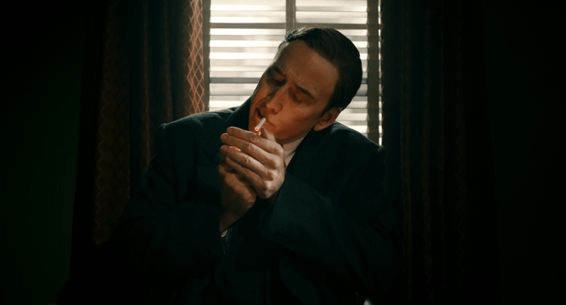 Nicolas Cage's Ben Reilly lighting a cigarette in Spider-Noir.