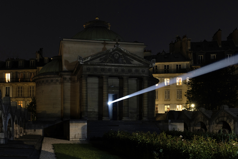 a beam of white light carves through paris' historical chapel - 1