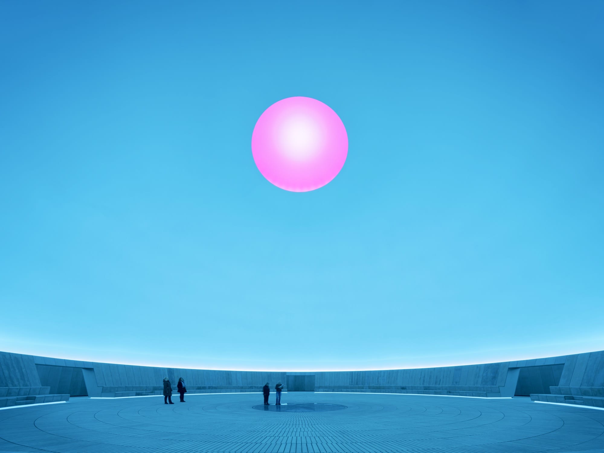 a large-scale light exhibition by James Turrell featuring a pink hole in a blue dome