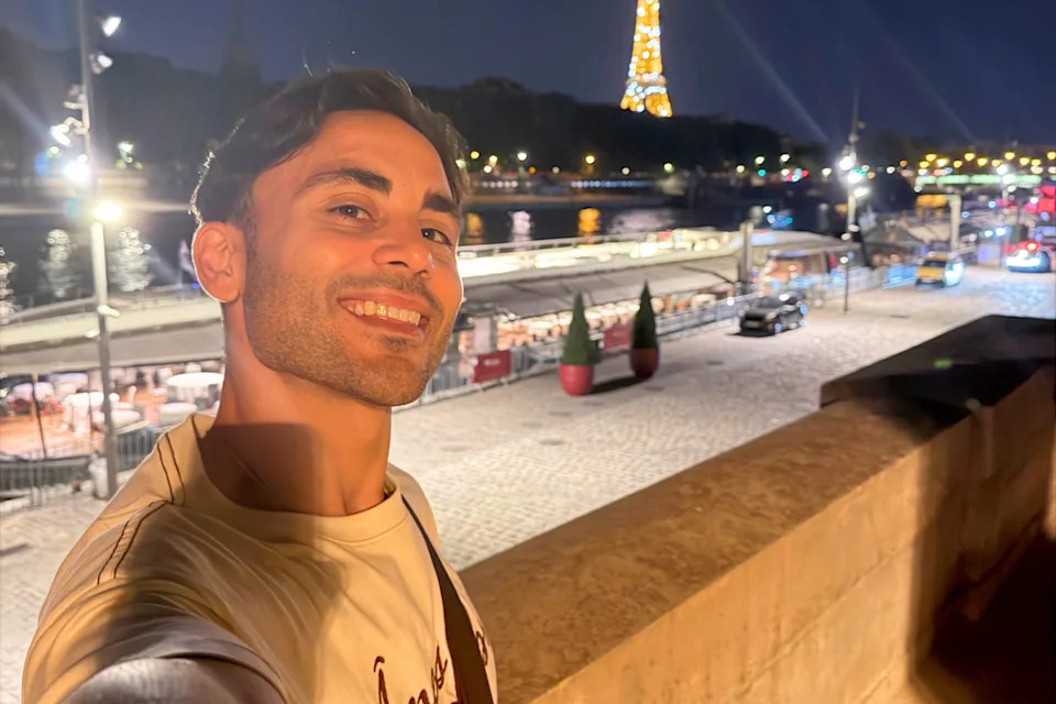 Australian tourist taking a selfie in Paris at night.