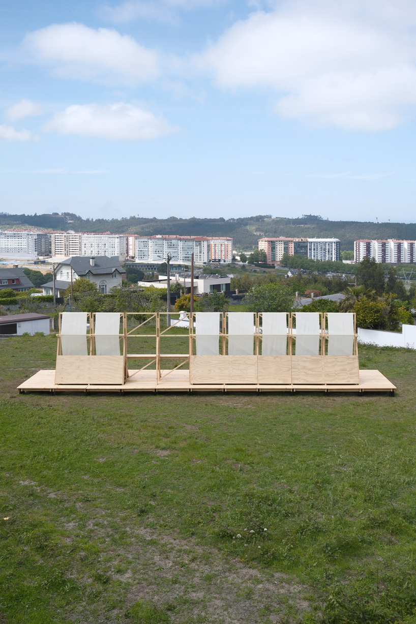 diagonal timber wall installation becomes furniture, shelter, and landscape frame in spain - 1