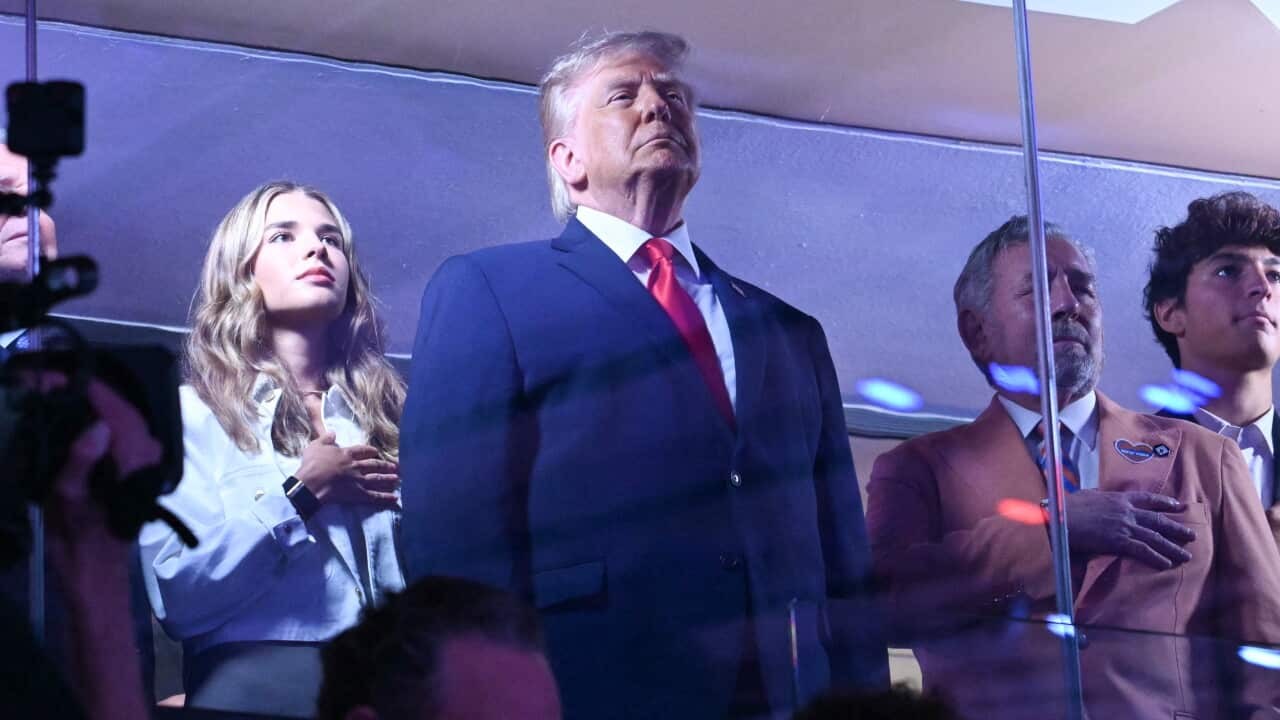 Trump standing in front of a few others in a box at Madison Square Garden
