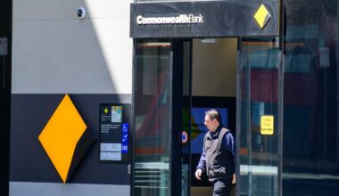 A man walking out of a Commonwealth Bank branch.
